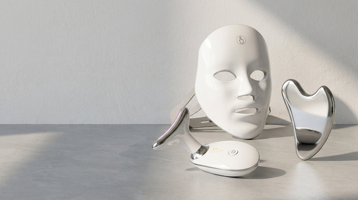 SENVÈ gua sha, Neck & Face Device and LED light therapy mask arranged on a pale stone surface