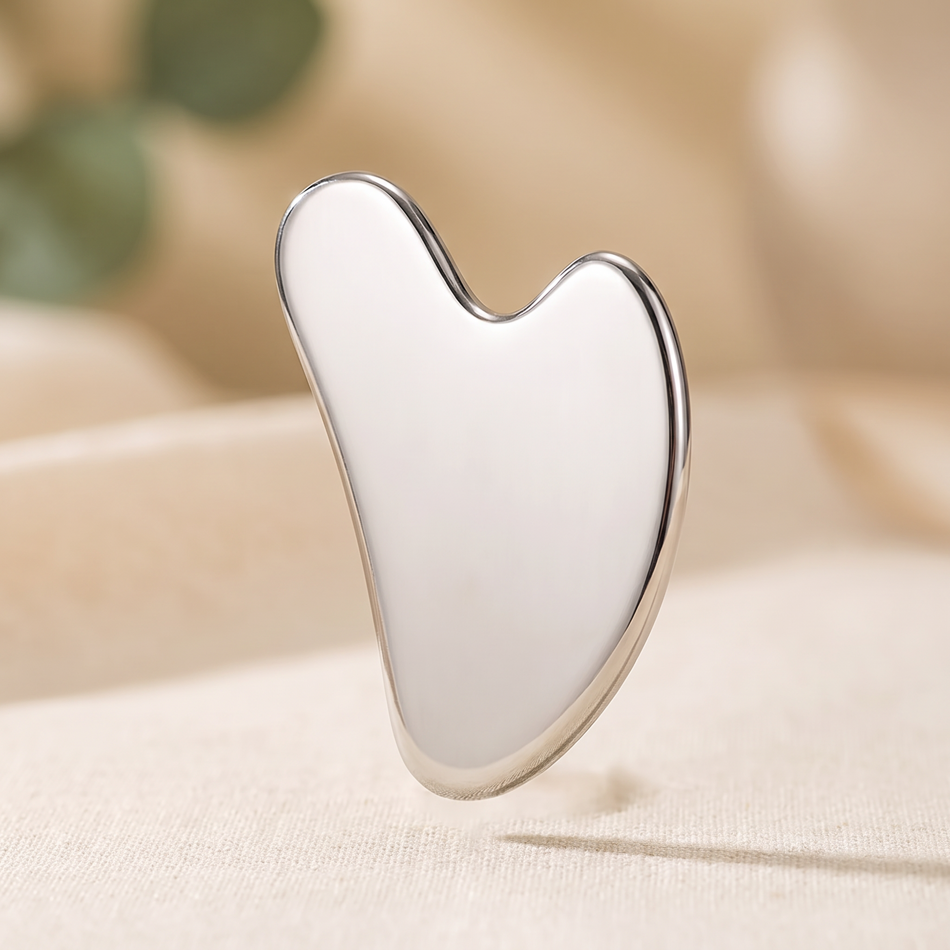 Senvè Gua Sha standing upright, polished stainless steel close up