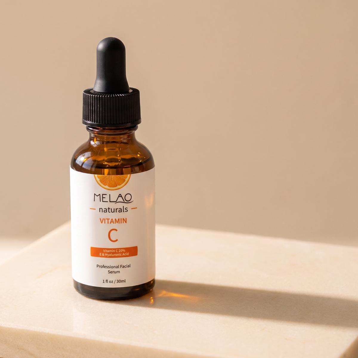MELAO Naturals Vitamin C Serum bottle at an angle on a stone surface