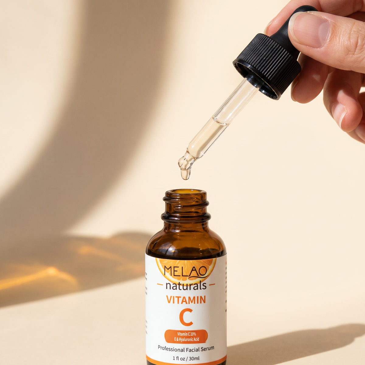 MELAO Naturals Vitamin C Serum dropper lifted from the bottle with a single drop